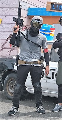 管理人の春夏のサバゲーの服装(ヘルメットとゴーグル・グレーのTシャツと黒い長そでのインナー・黒いズボンでライフルを持つ)