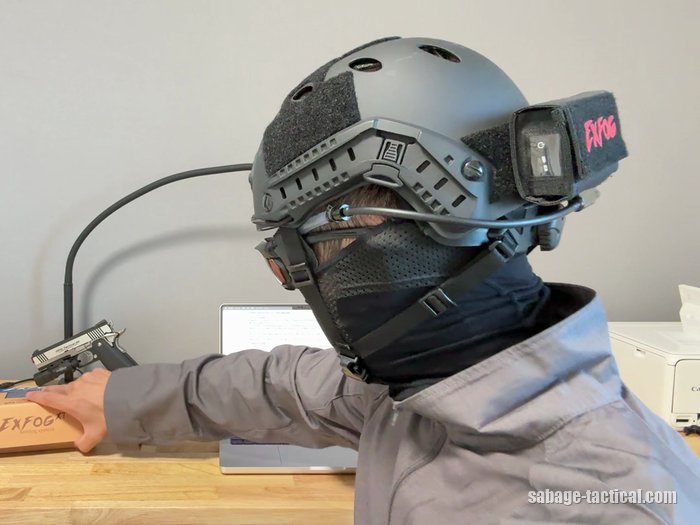 管理人のフル装備を斜めうしろから。ヘルメットのうしろのポーチに入れたExFog XTの本体から、チューブがゴーグルへ